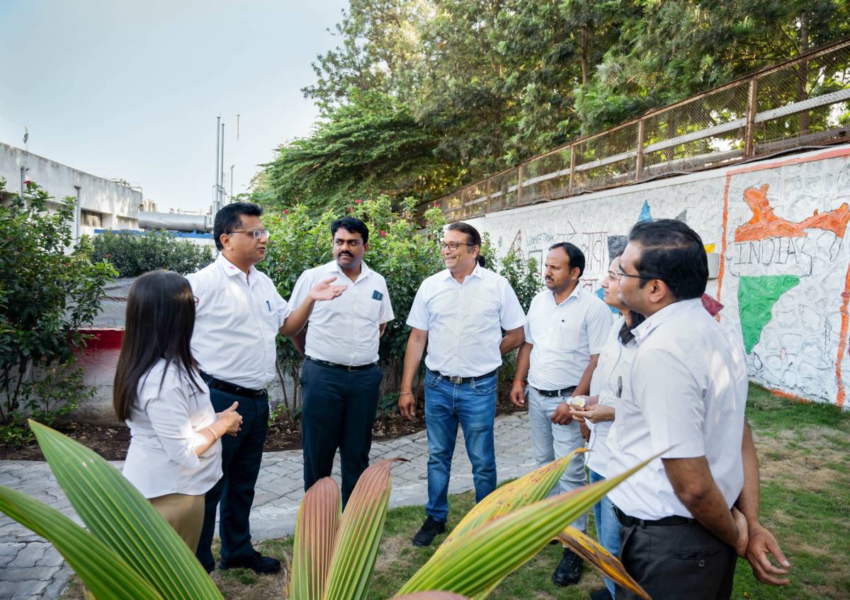 Huf India employees talking in the garden area of the plant.