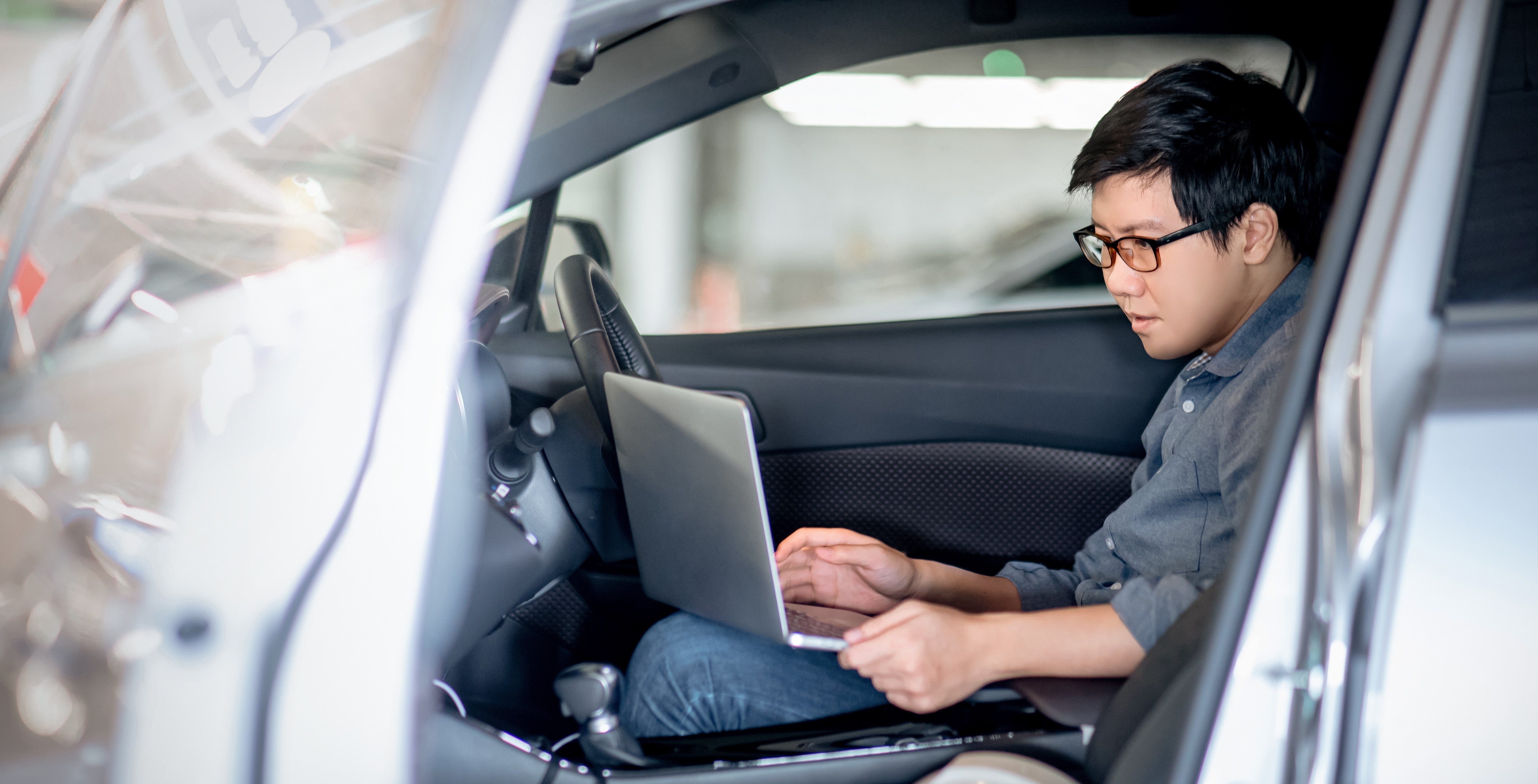 Huf job offer asian engineer working in car with notebook