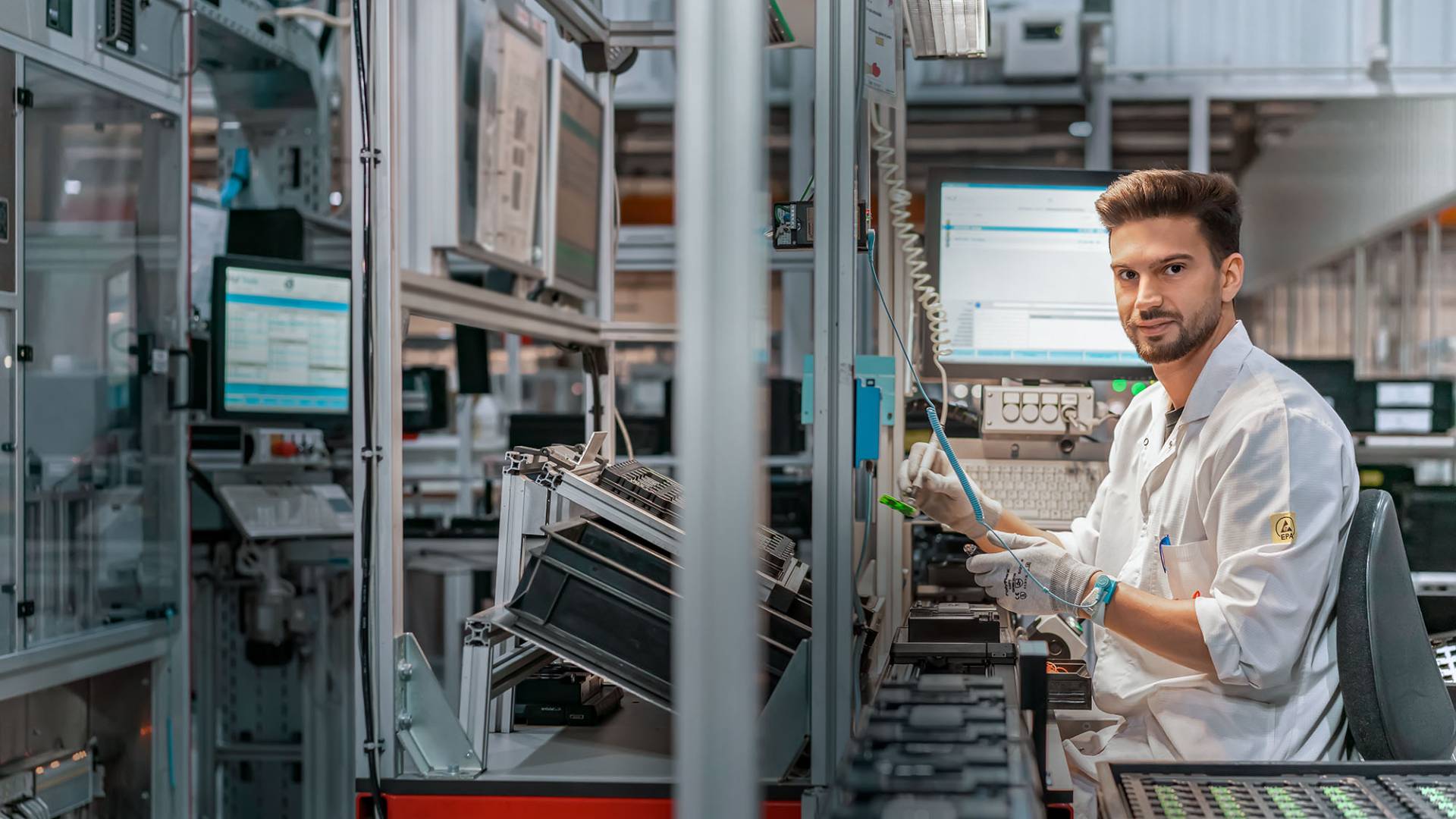 Young worker at electronics pcb production for smart keys at huf automotive supplier