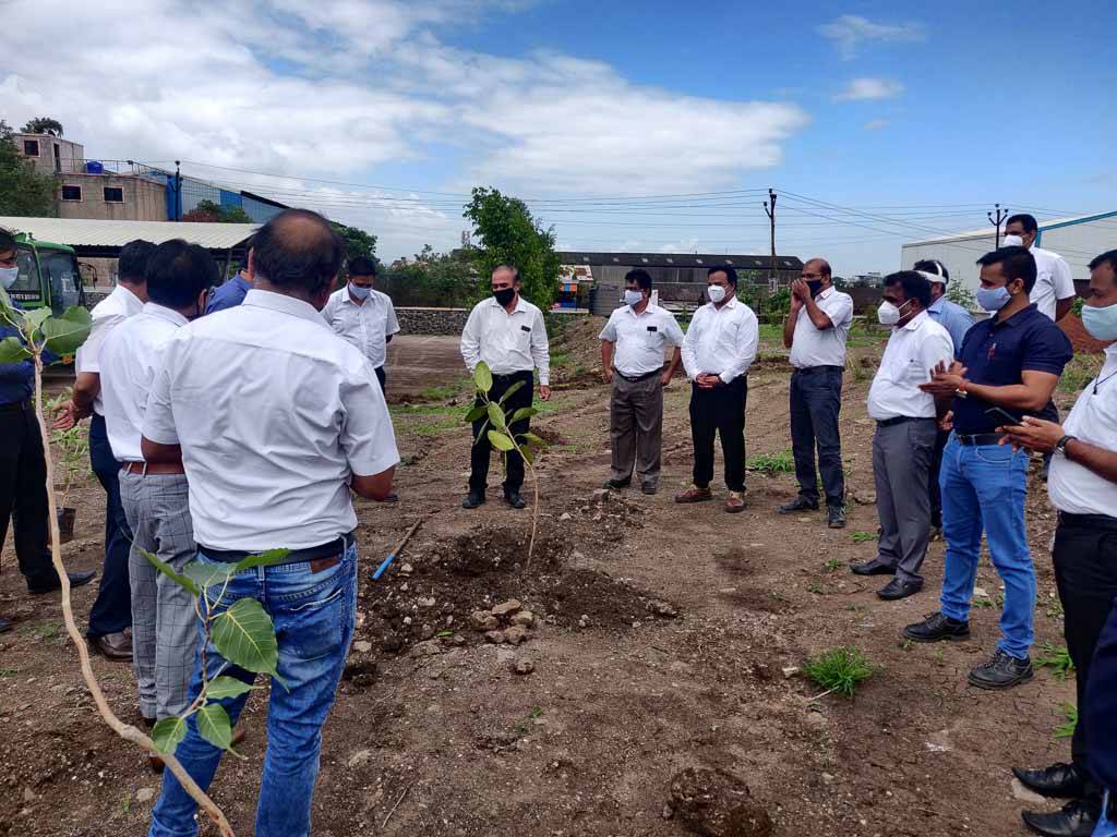 People standing around a newly planted tree at the Huf India site in Pune