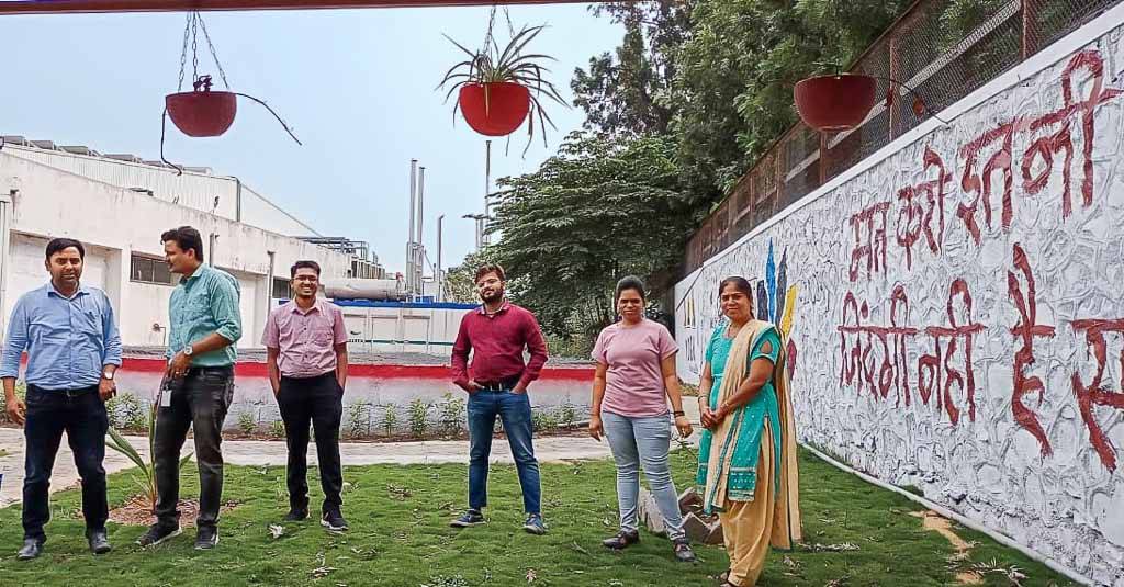 People in front of the water reservoir of the Huf India site in Pune