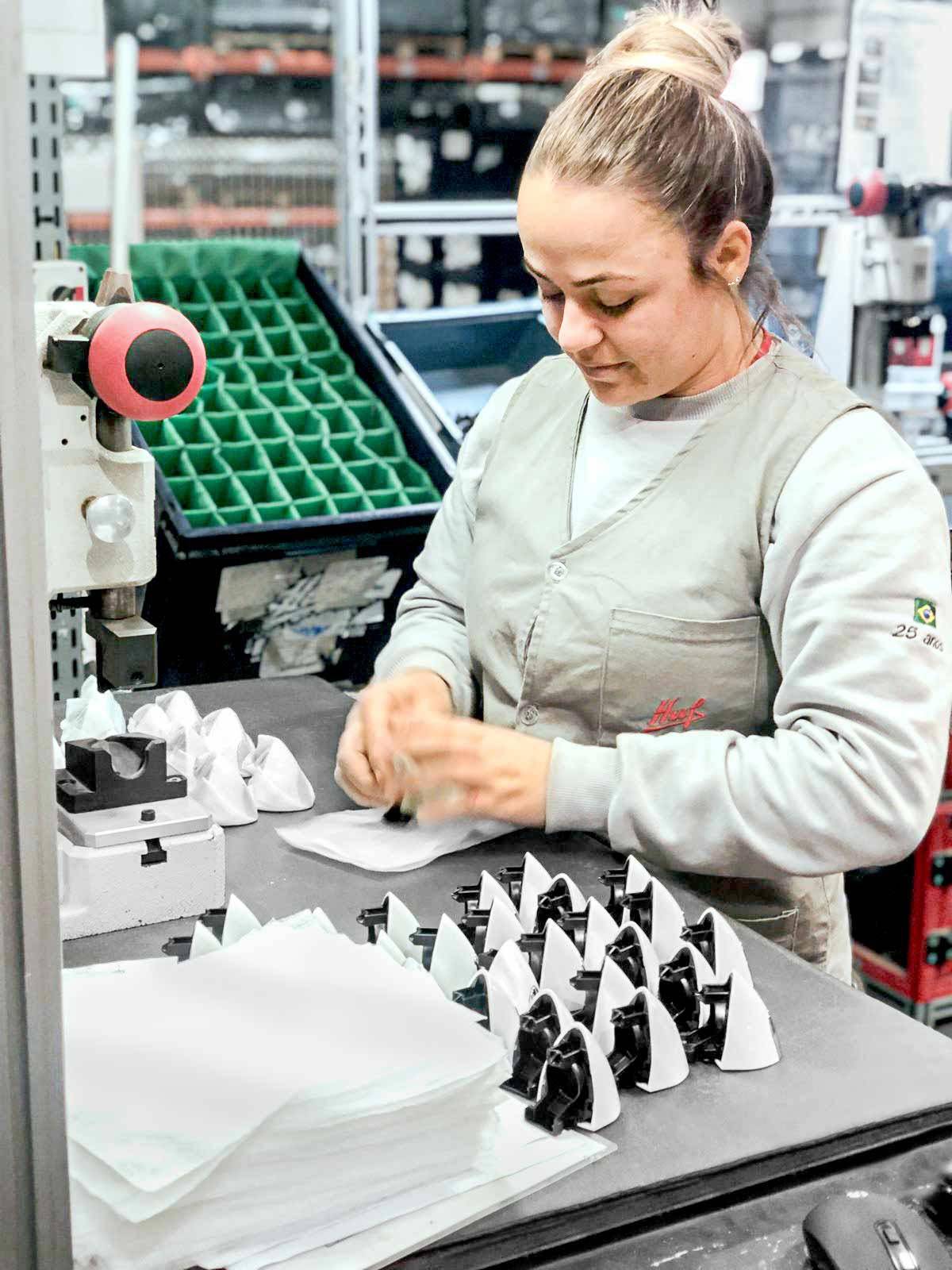 Female worker producing car keys at the Huf Brazil factory.