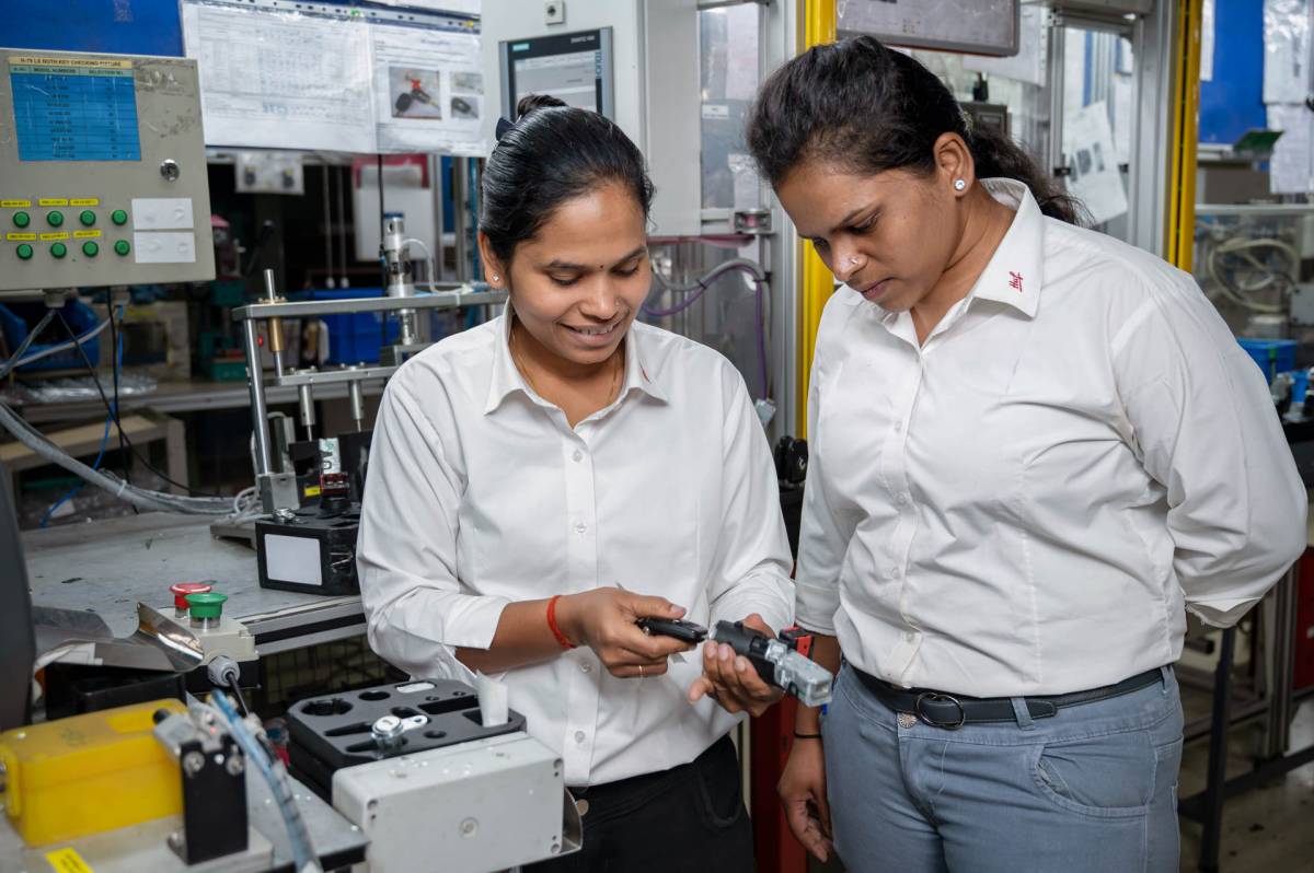 Two female employees of Huf India in Pune at work holding a key.