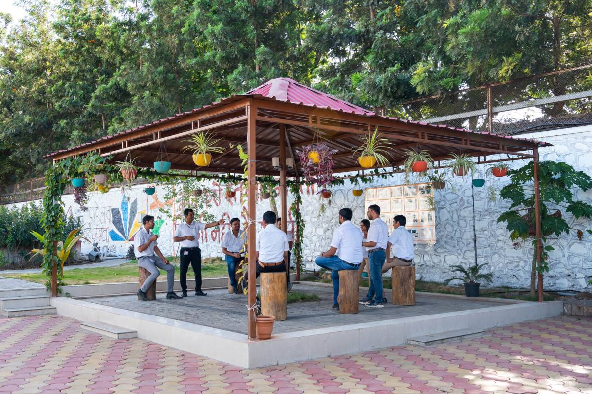 Huf India employees talking in the plant's garden pavilion.