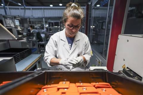 Female worker at Huf Protugal checking quality of remote control car key production